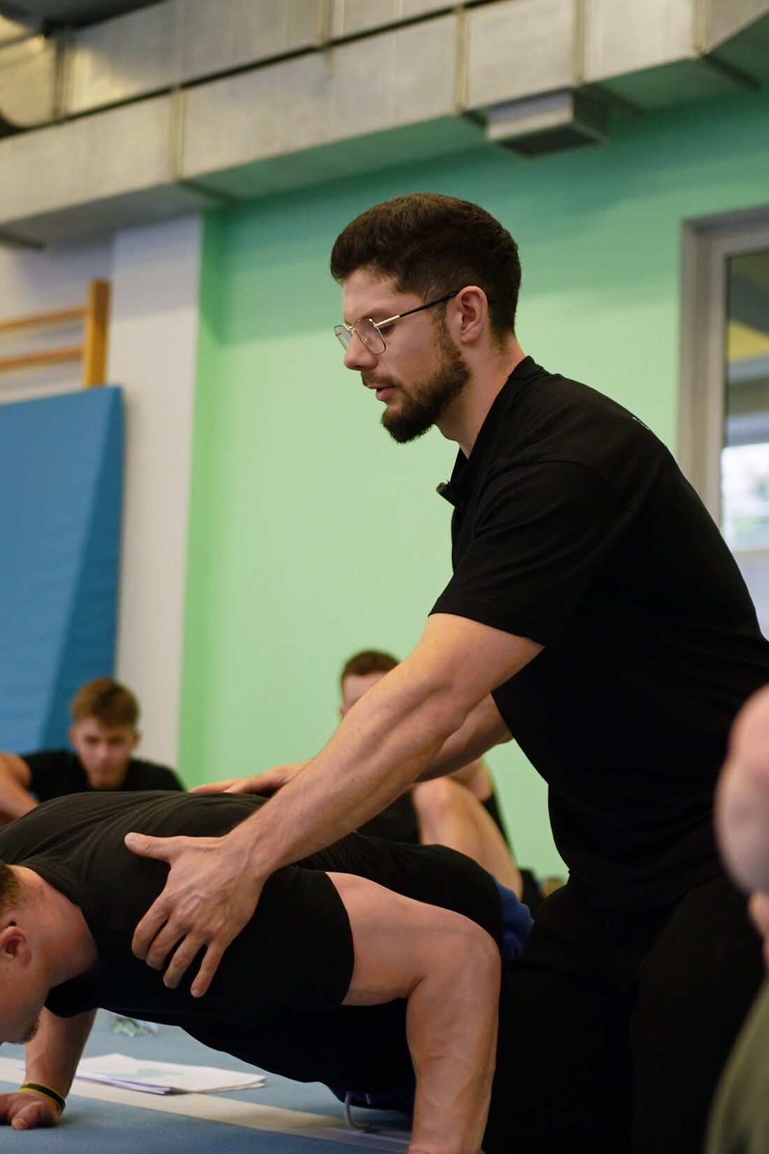 Prowadzący koryguje technikę uczestnika kursu trenera street workout i kalisteniki